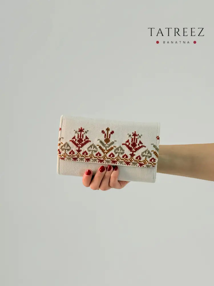 Handmade suede wallet with traditional Palestinian tatreez embroidery in red and gold, elegant and practical accessory for everyday use