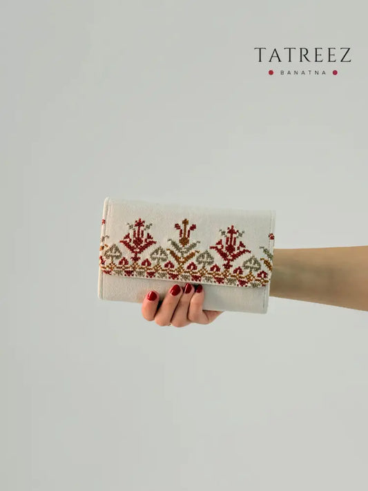 Handmade suede wallet with traditional Palestinian tatreez embroidery in red and gold, elegant and practical accessory for everyday use