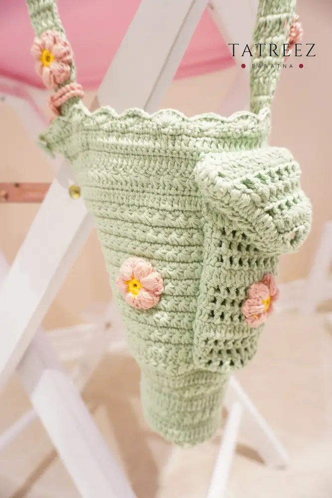 Bright green handmade crochet Stanley bottle holder with pink and yellow flowers, front pocket, and hand strap – fits 30oz, made with Alize cotton