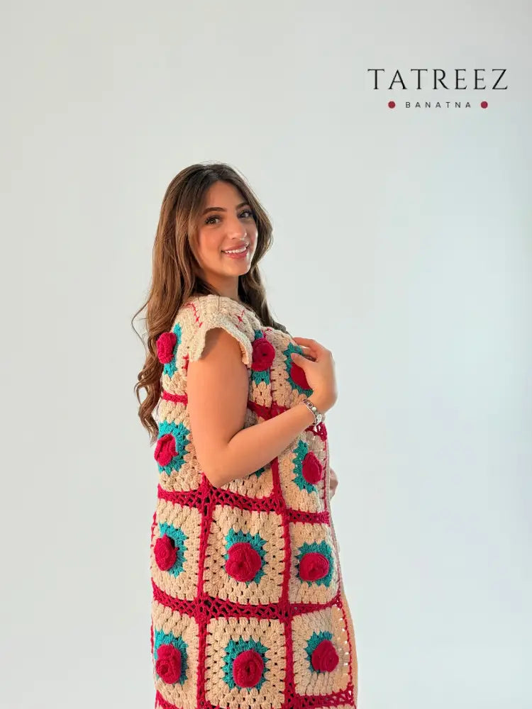 Elegant sleeveless cardigan with a floral pattern in turquoise and fuchsia, handcrafted with care and attention to detail.