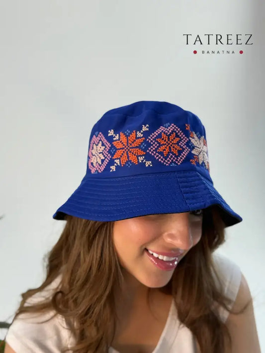 Navy bucket hat with elegant handmade embroidery, crafted by artisans from the Refuge of Gaza in Jordan, showcasing modern style and cultural significance.