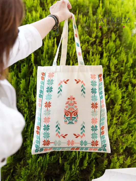 Linen beige tote bag with teal and coral Palestinian tatreez embroidery, handmade by women artisans, eco-friendly and spacious.