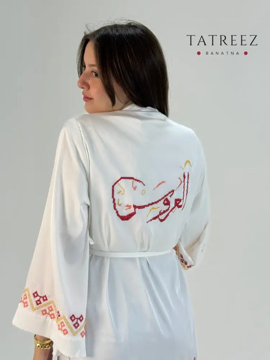 White silk bridal robe with red Palestinian tatreez embroidery and bride map design, handmade for weddings