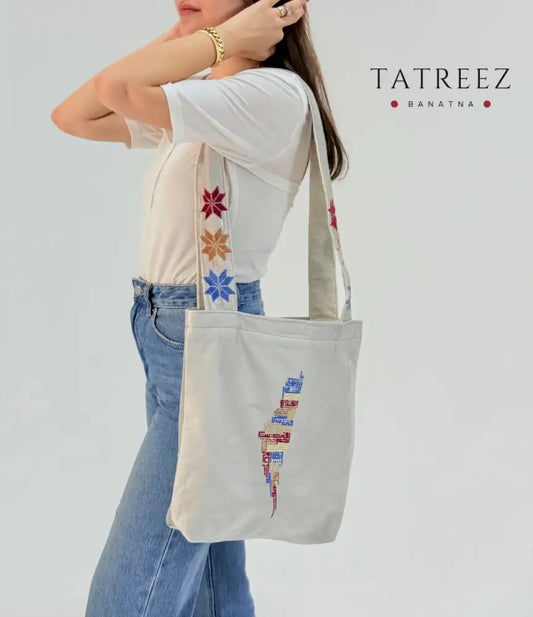Handmade Shemwa tote bag with embroidered Palestinian map and floral strap details, crafted by Palestinian women artisans.