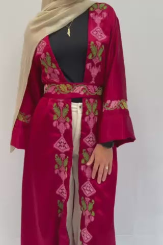Handmade linen abaya robe with Palestinian embroidery and a stylish belt. The robe has a shoulder length of 45 cm and an overall length of 128 cm. Model is approximately 163 cm to 165 cm tall wearing a small size, highlighting the robe's elegance.
