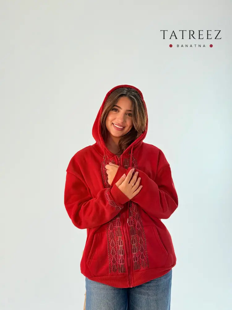 Red zipper hoodie featuring beautiful handmade Tatreez embroidery on the sides and sleeve bracelet, showcasing unique artisan craftsmanship.