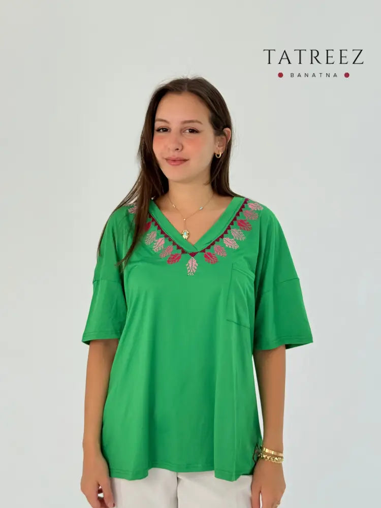 Soft green cotton t-shirt with handmade embroidery on the neck, offering comfort and elegance.