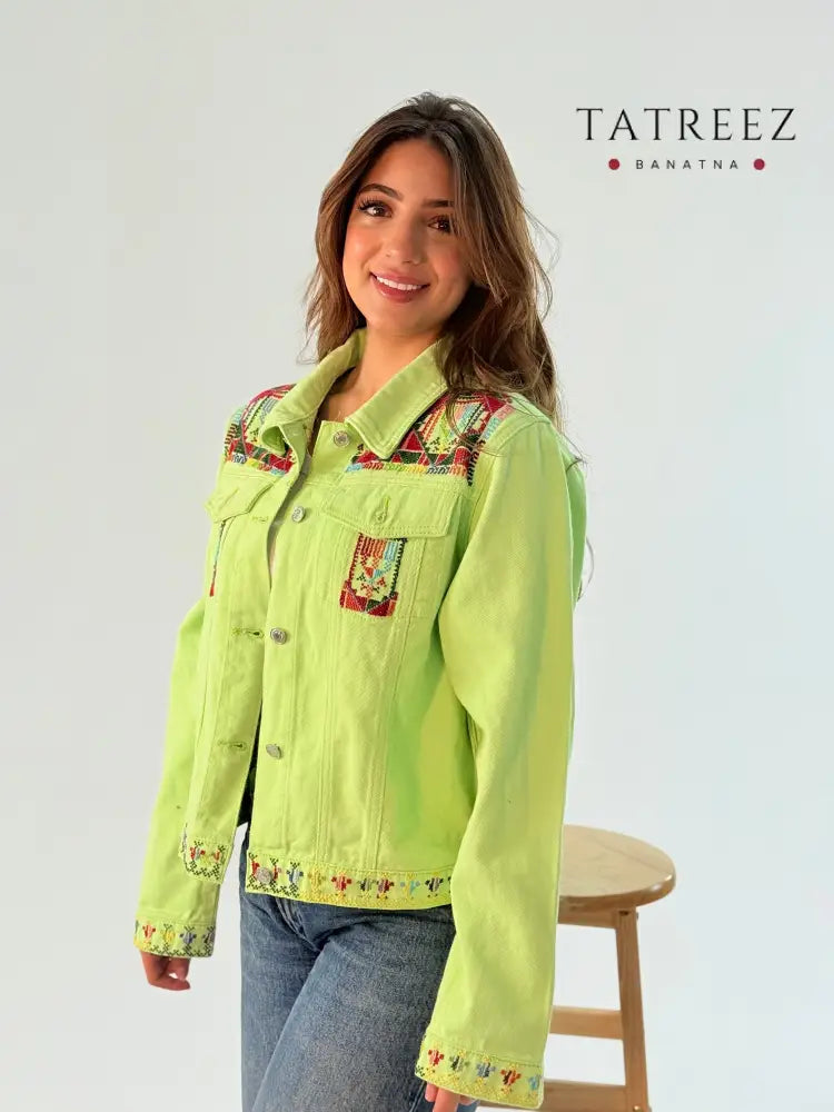 Pistachio green jeans jacket featuring handmade embroidery on the front and back, showcasing unique artisan craftsmanship.