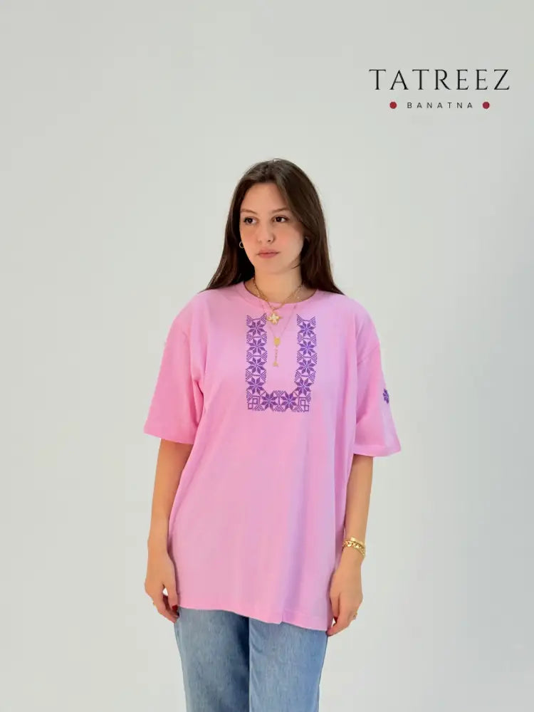 Cotton t-shirts in light blue and pink with U-shaped Palestinian tatreez embroidery, modeled with jeans, handmade by women artisans