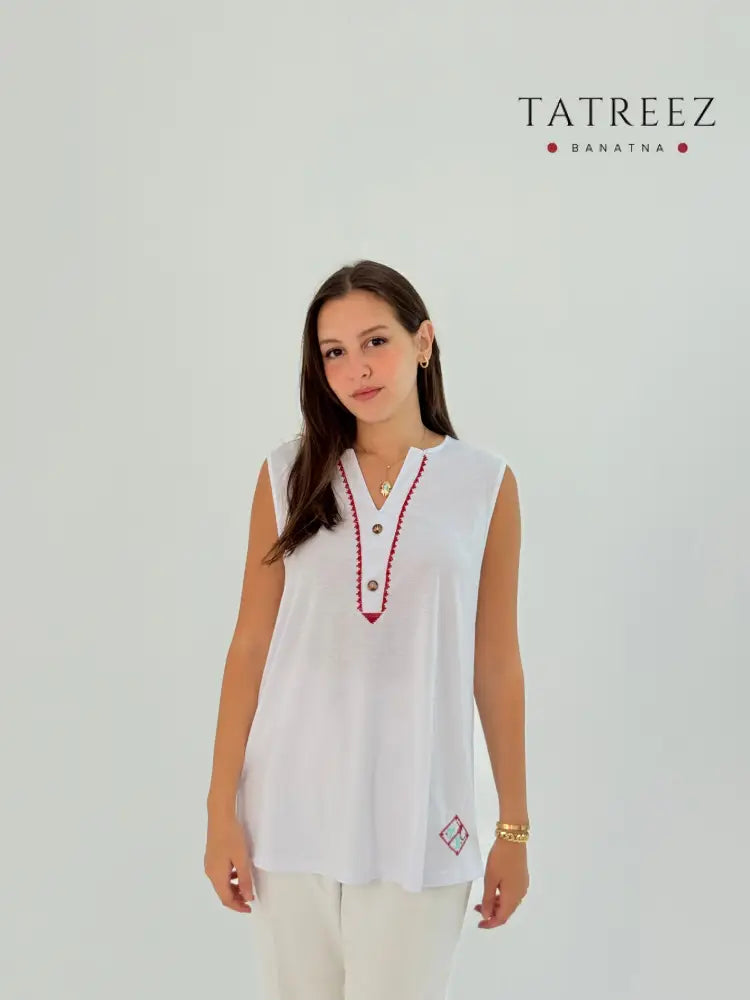 White cotton shirt with 'Ala Hathehe Elardh' design, blending modern style with traditional elements.