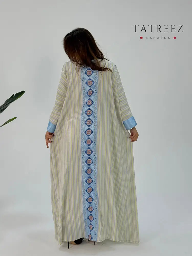 Zahra Abaya: Handmade baby blue striped satin and Cornish satin fabric abaya with elegant embroidery on the front and back, designed for sophistication and customizable for every occasion, perfect for enhancing a woman's beauty.